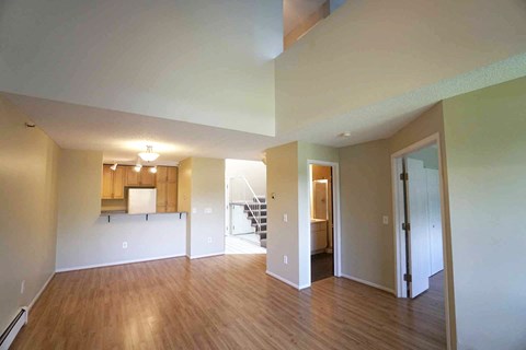7602 York empty living room with wood flooring and a kitchen
